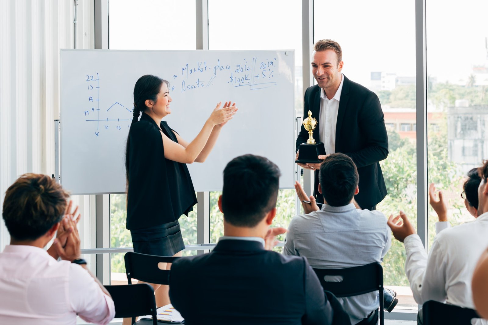 boss awarding workers during conference